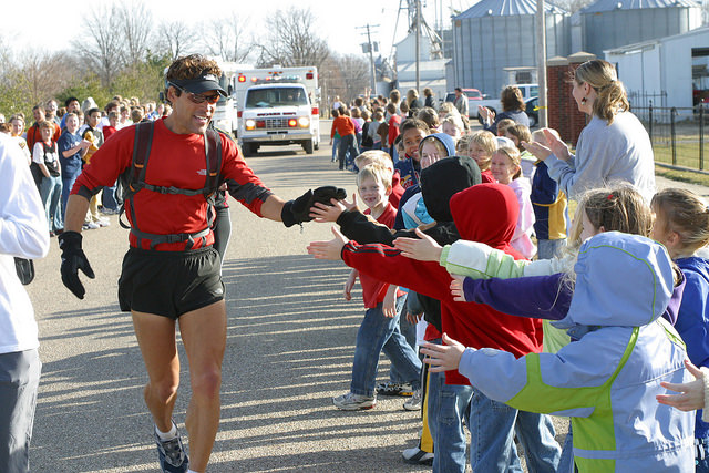Dean Karnazes giving high five to kids while running