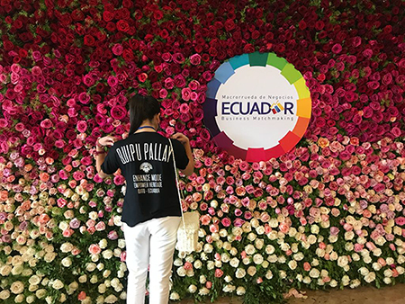 Perugachi standing by a wall of roses, which are one of Ecuador’s top export products. She says that by being part of a larger community of women entrepreneurs, AWE helped her to feel less alone.