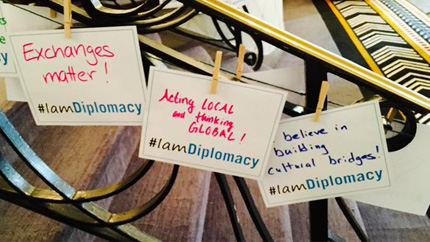 Handwritten signs incorporating the #IAmDiplomacy hashtag