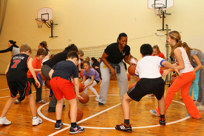 Young Ukrainian athletes learn new dribbling techniques during a fun basketball activity with Tamika Raymond.