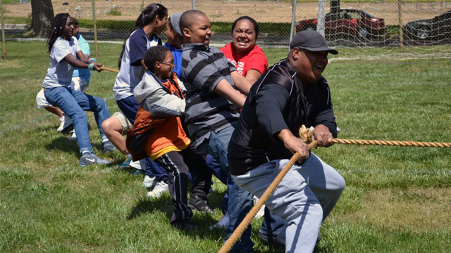 The group shows their strength and teamwork with the students of Paul Public Charter School during a tug of war activity.