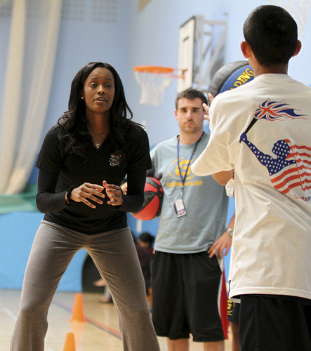 Swin Cash shares her skills through drills with a young player from England.