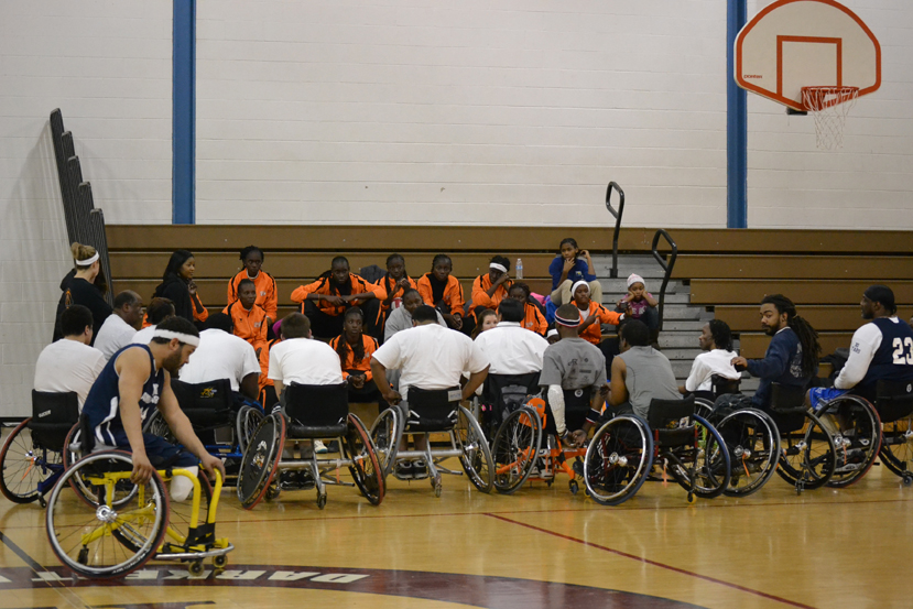 The young women have their first experience playing wheelchair basketball to learn about sports opportunities for people with disabilities.