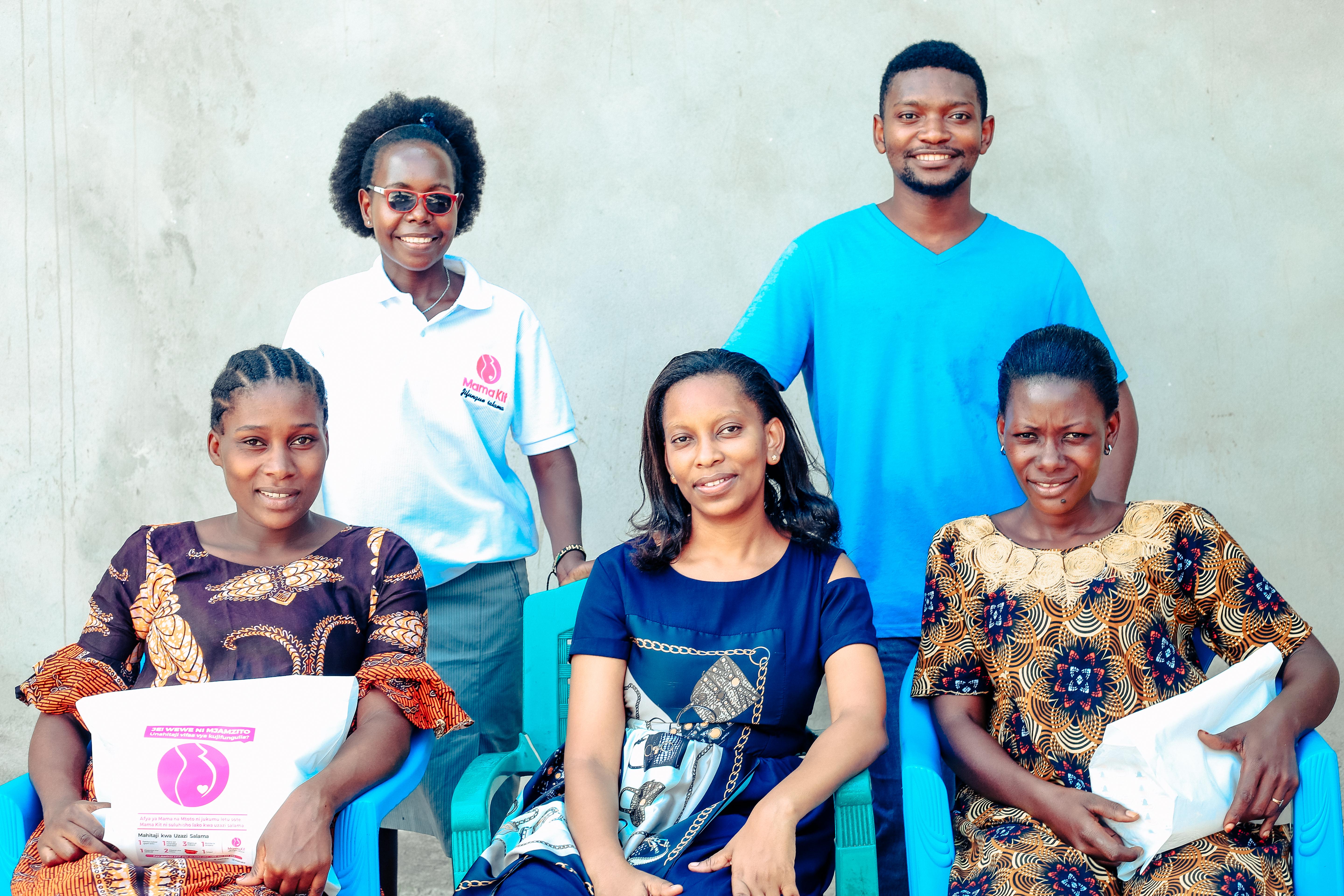 Lucy Chuwa (center) and the Mama Kits team smile with two Mama Kits recipients.