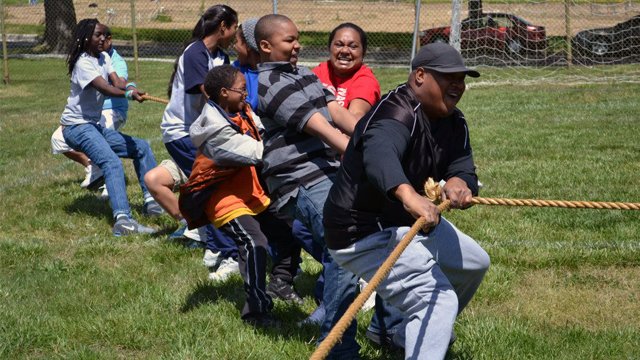 The group shows their strength and teamwork with the students of Paul Public Charter School during a tug of war activity.