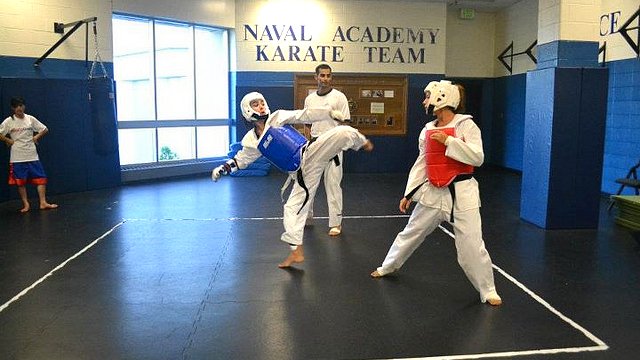 The coaches spar with the Naval Academy’s taekwondo team.