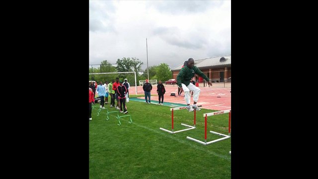 The participants practice different track and field events including shot put and hurdles.