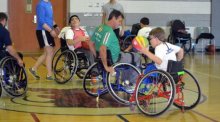 Participants in wheelchairs doing exercise in a gym