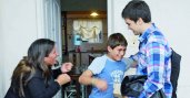 National Youth Science Camp alumnus Gino Tubaro presents an 11 year-old boy with a prosthetic hand he created using a 3D printer.