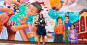 banner image of woman playing the guitar in front of a colorful mural