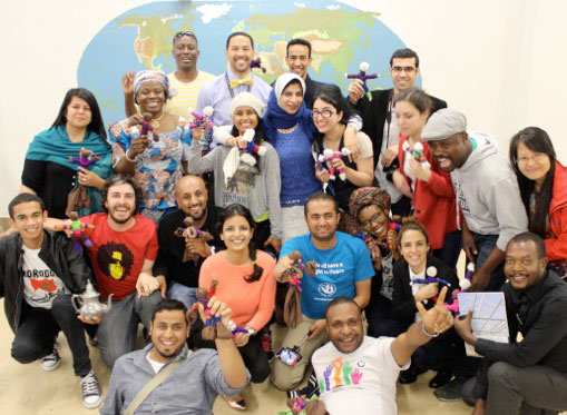 Participants pose in front of the world map they created